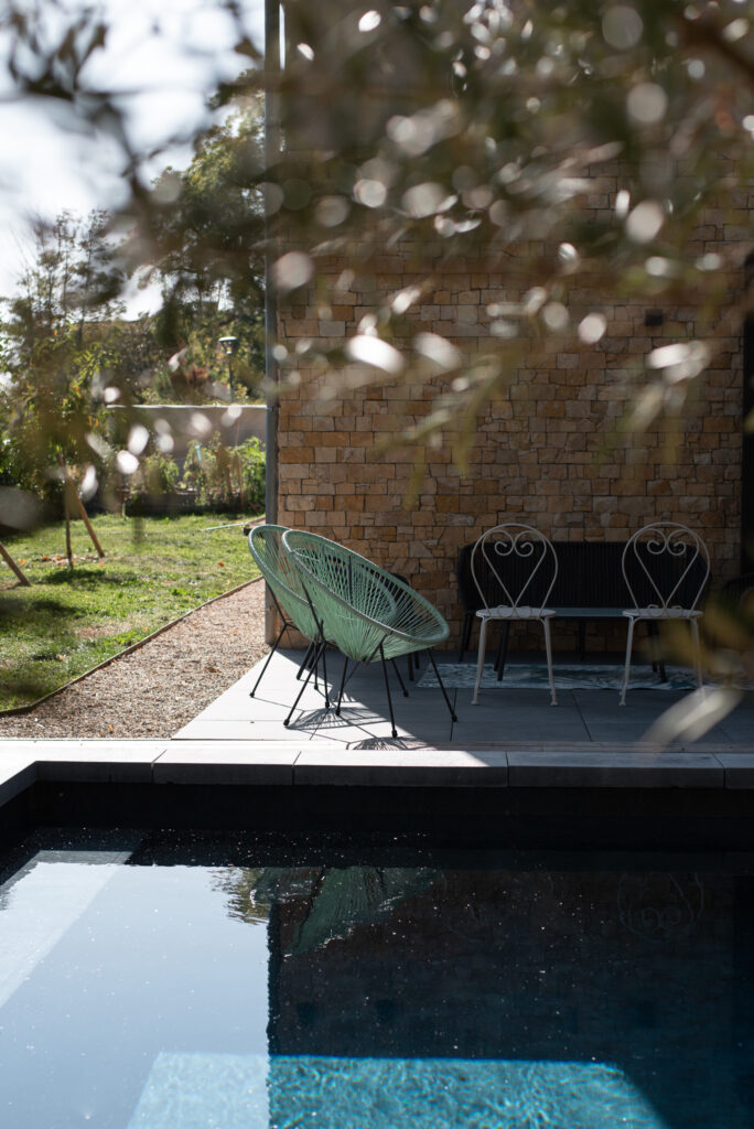 Fauteuil et terrasse ombragée au bord de la piscine