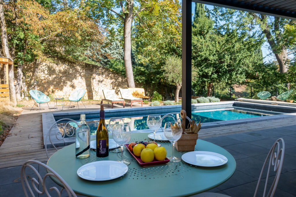 Table de jardin et terrasse couverte donnant sur la piscine