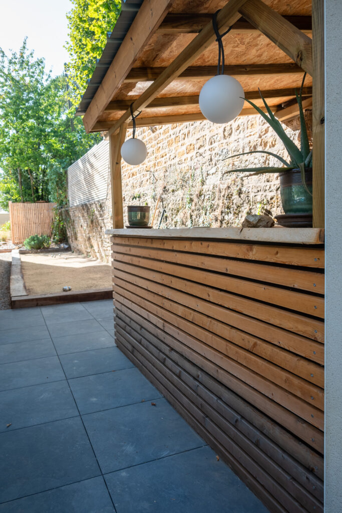 Passage dallé le long du bar extérieur en bois
