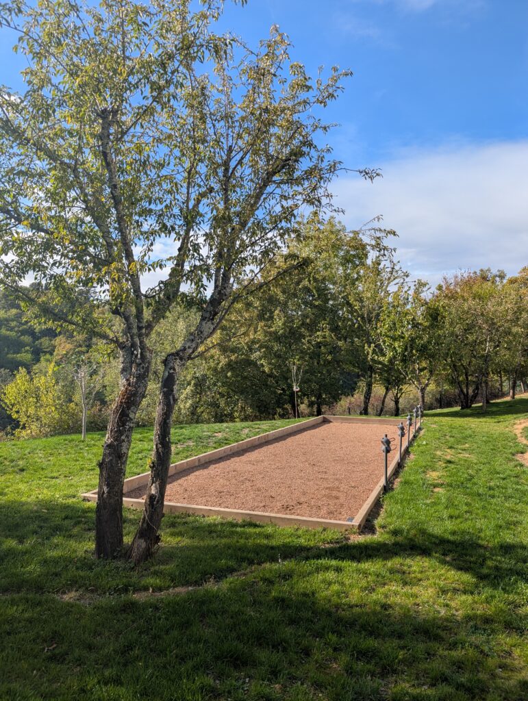 Terrain de pétanque bordé de bois sous les arbres dans un jardin à Saint-Didier-au-Mont-d’Or