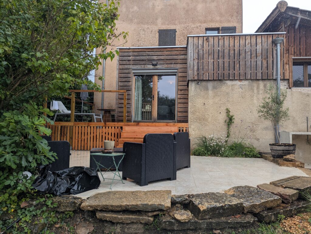 Terrasse en bois et architecture d’une ancienne ferme rénovée à Dardilly