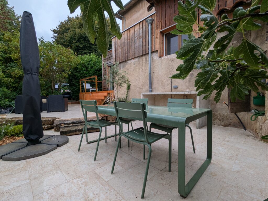 Terrasse de repas en bois ouverte sur un jardin champêtre à Dardilly