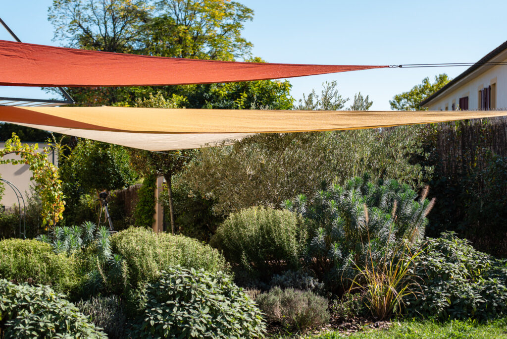 Massifs denses et voiles d’ombrage dans le jardin