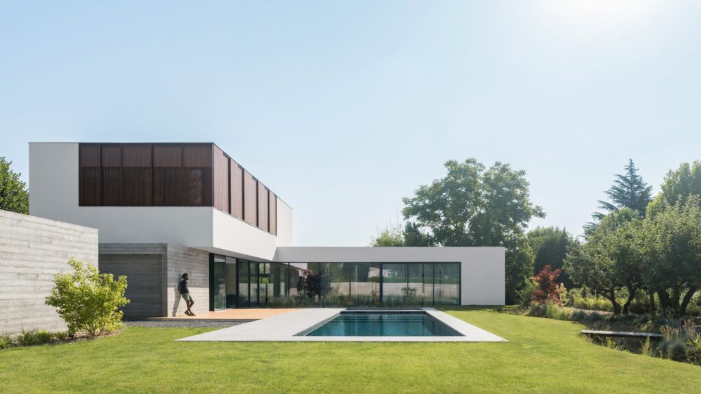 Vue frontale de la maison contemporaine, de la piscine et du jardin paysager